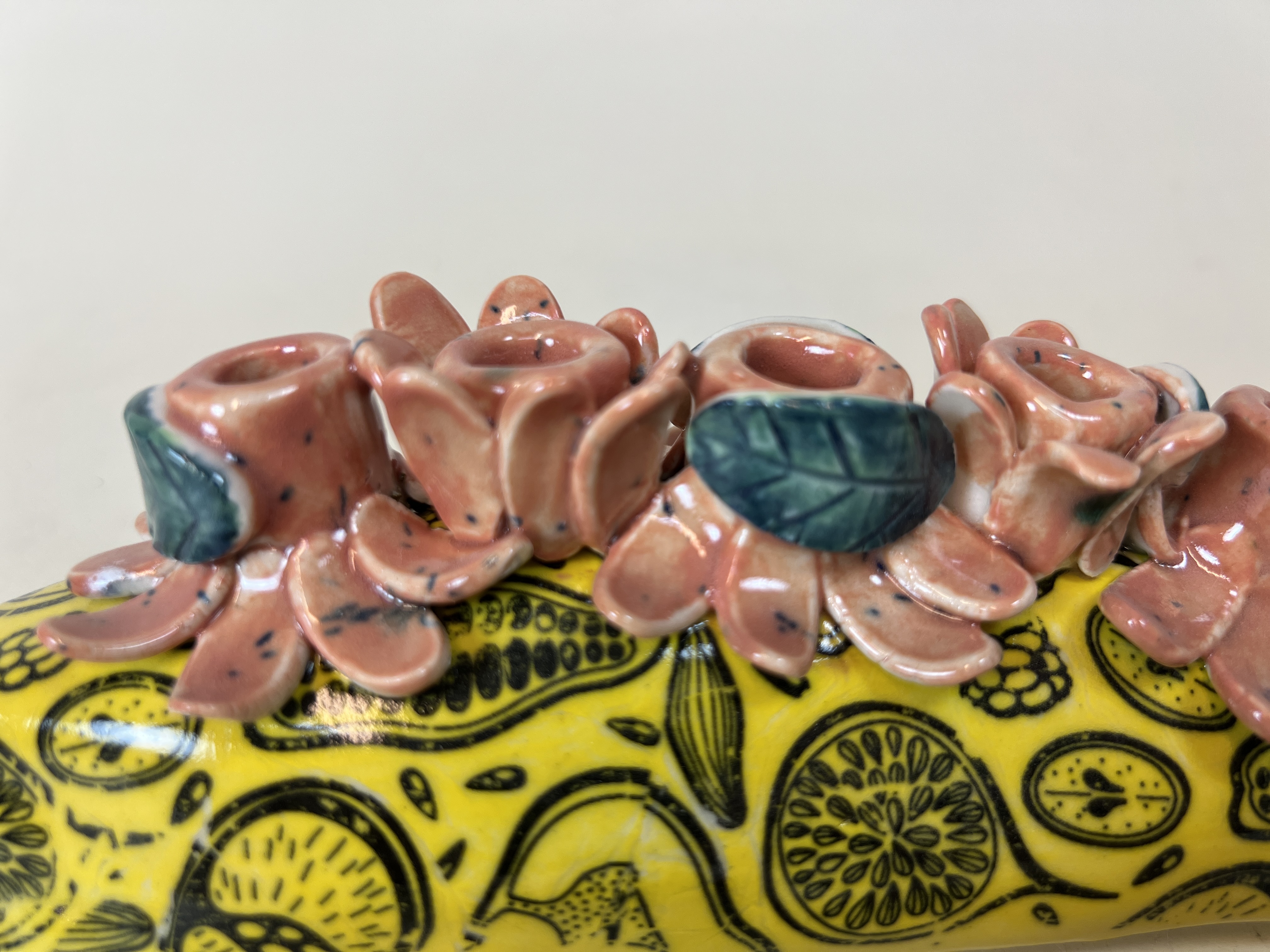 Yellow ceramic candelabra with fruit pattern detail